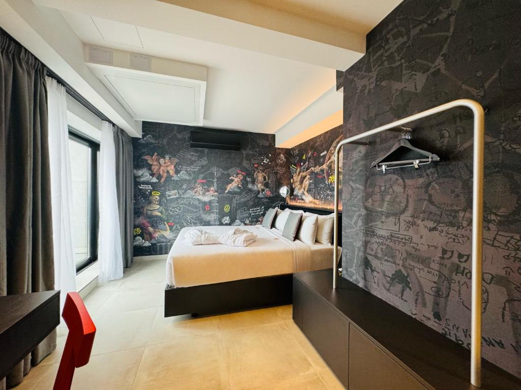 a bedroom with a bed and a wall covered in wallpaper at SO City Hotel Adults Only in St. Julianʼs