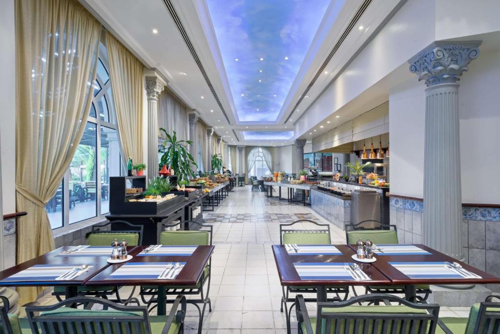 una sala da pranzo con tavoli e sedie in un ristorante di Radisson Blu Hotel, Muscat a Mascate