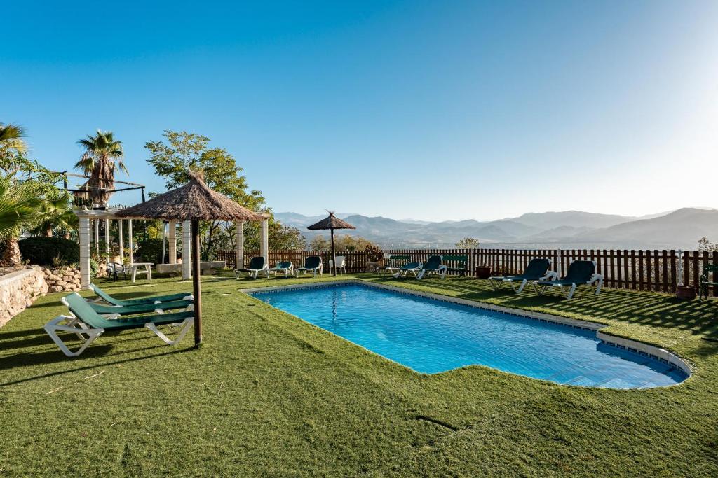 アロラにあるCasa Rural Salrimaのスイミングプール(椅子、パラソル付)