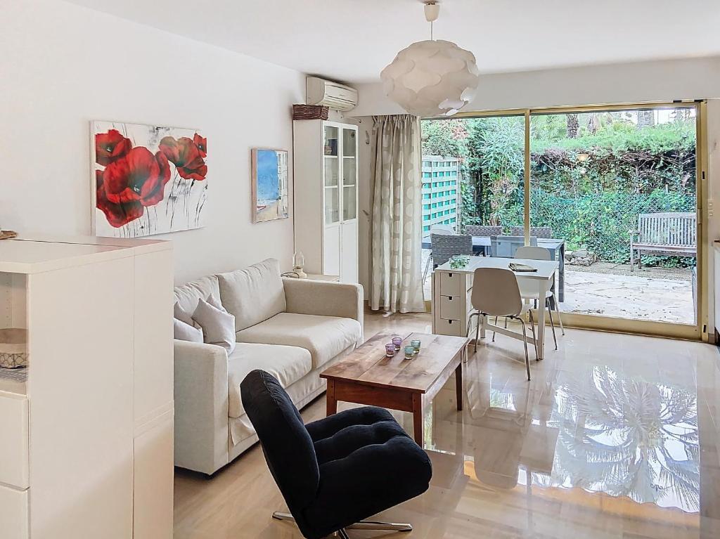 un salon avec un canapé et une table dans l'établissement A 2 pas des plages piscine 183L STENJ, à Cannes