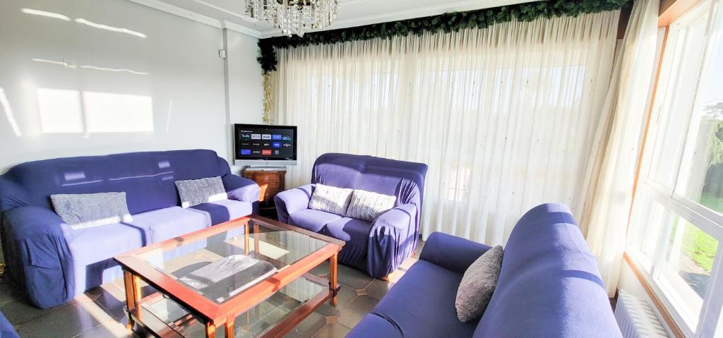 a living room with purple couches and a tv at Villagalicia360 in Bergondo