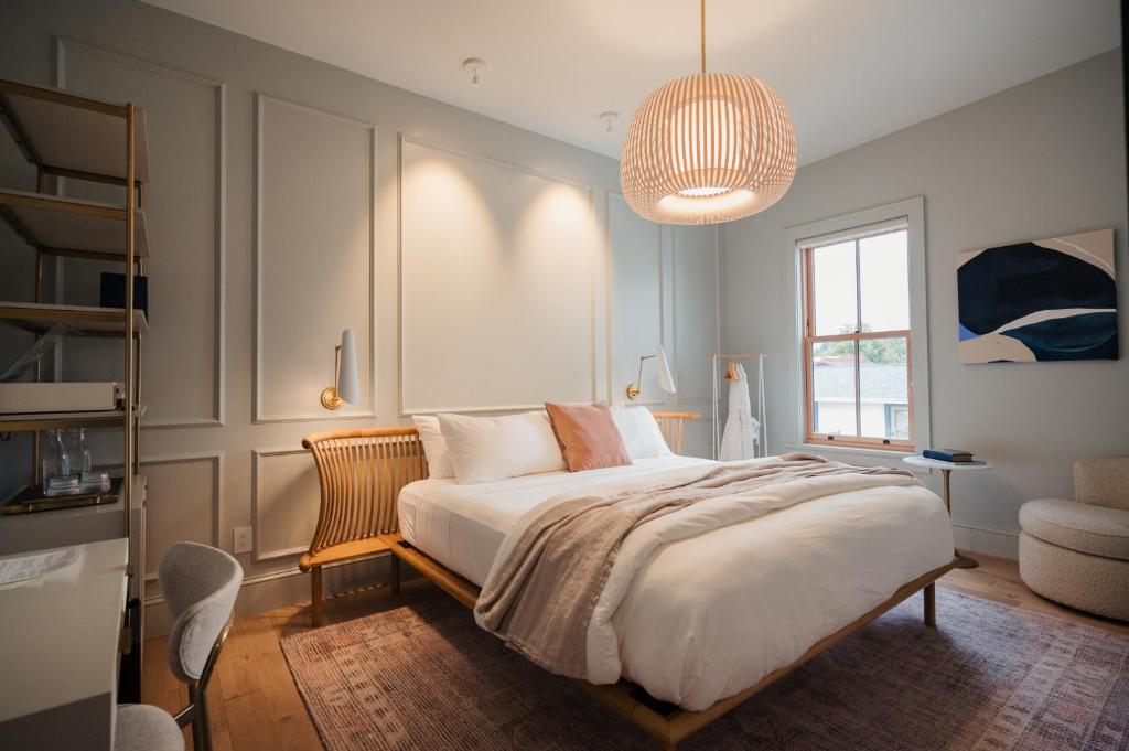 a bedroom with a large bed and a chandelier at St. James Social in Bayfield