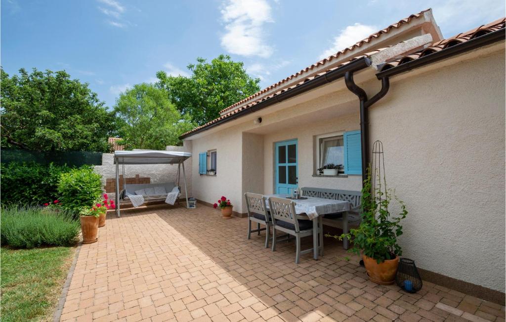 patio ze stołem i krzesłami obok domu w obiekcie 2 Bedroom Stunning Home In Sisan w mieście Šišan