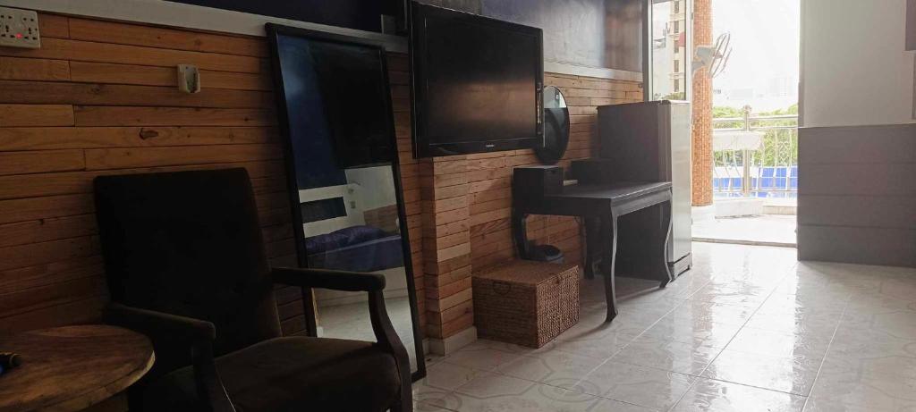 a room with a wall with a tv and a table at Little Susie Family Room in Phnom Penh