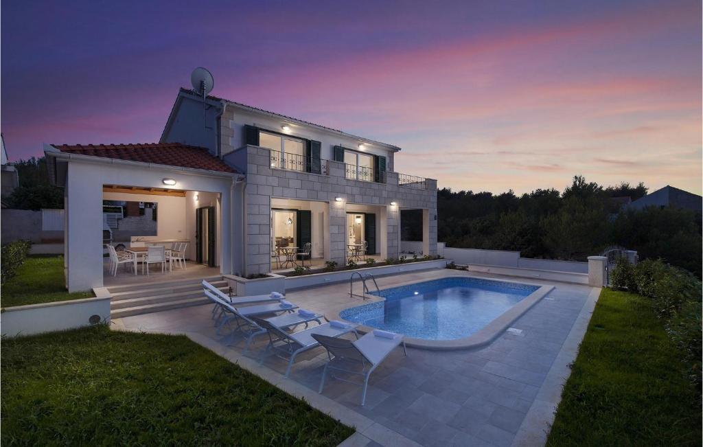 a villa with a swimming pool in front of a house at Villa Makarac in Milna