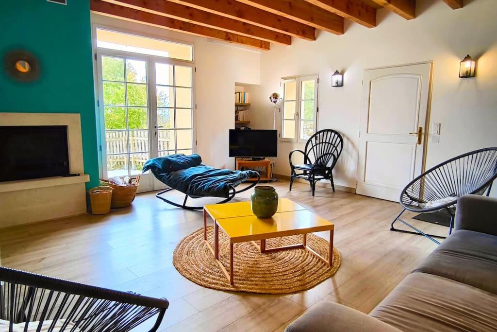 un soggiorno con un divano e un tavolo di Grande maison de charme avec piscine 11 pers a Charras