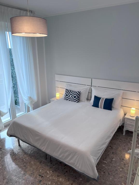 a bedroom with a large white bed with blue pillows at B&Bononia View in Bologna