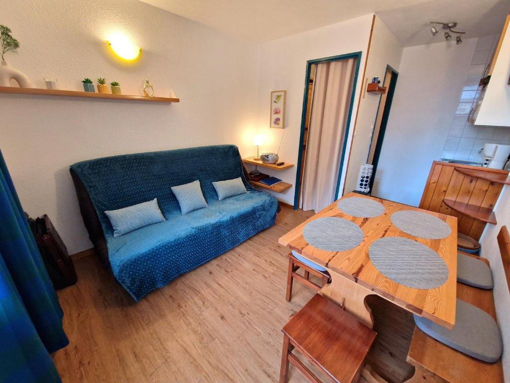 un salon avec un canapé bleu et une table dans l'établissement Studio central pour 3 pers., proche pistes - FR-1-265-359, à Modane