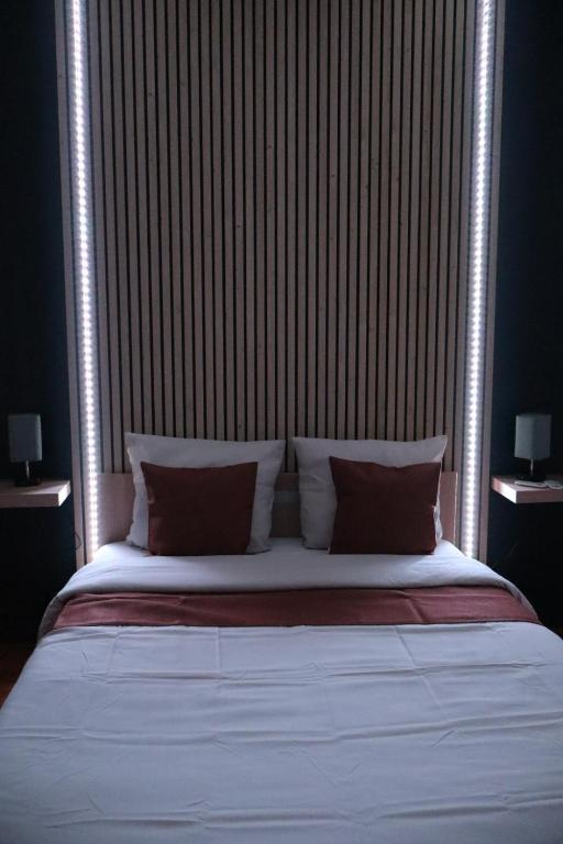 une chambre avec un grand lit avec une tête de lit en bois dans l'établissement Grand T2 - Rue de la République, à Orléans