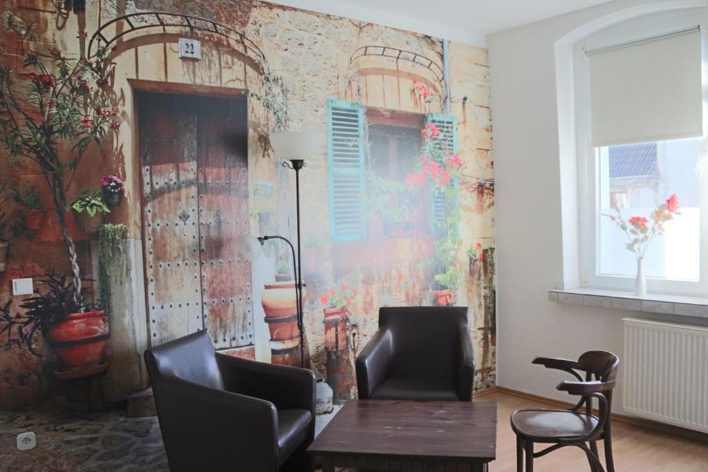 a room with a table and chairs and a wall at Pension Gladbeck - Ihre Pension im Ruhrgebiet in Gladbeck