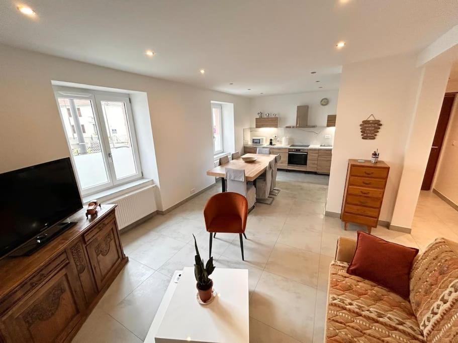 un salon avec un canapé et une table et une cuisine dans l'établissement Appartement neuf Mulhouse, à Mulhouse