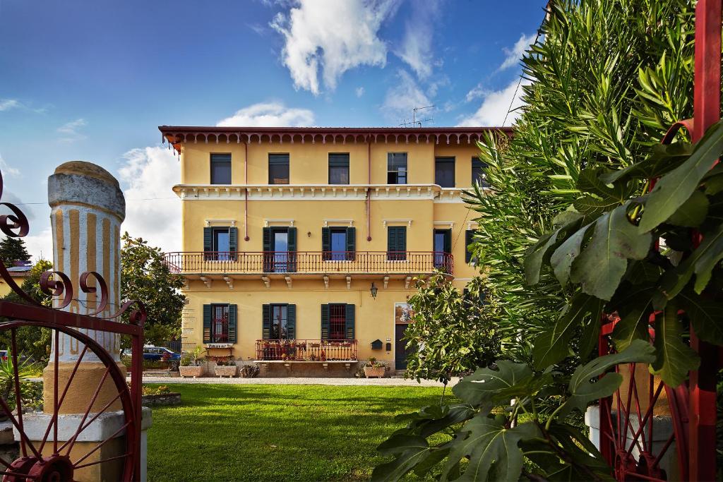 een groot geel gebouw met zwarte ramen en een tuin bij Giardino Ferrari in Verona