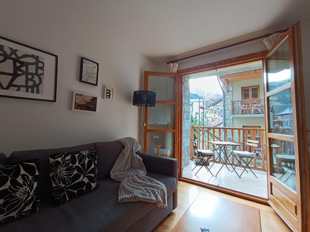 a living room with a couch and a balcony at InmoCyma Pico Posets Benasque in Benasque