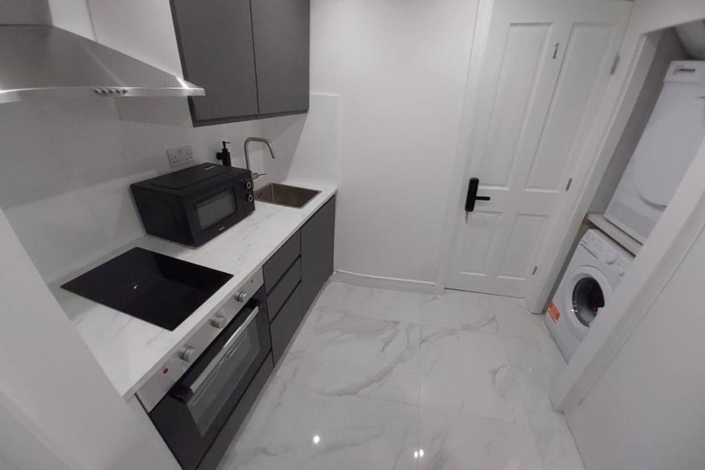 a small white kitchen with a sink and a microwave at Central London Zone 1 Room wbath in London
