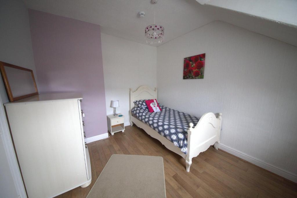 a small bedroom with a white bed and a painting at Ten in Bridlington