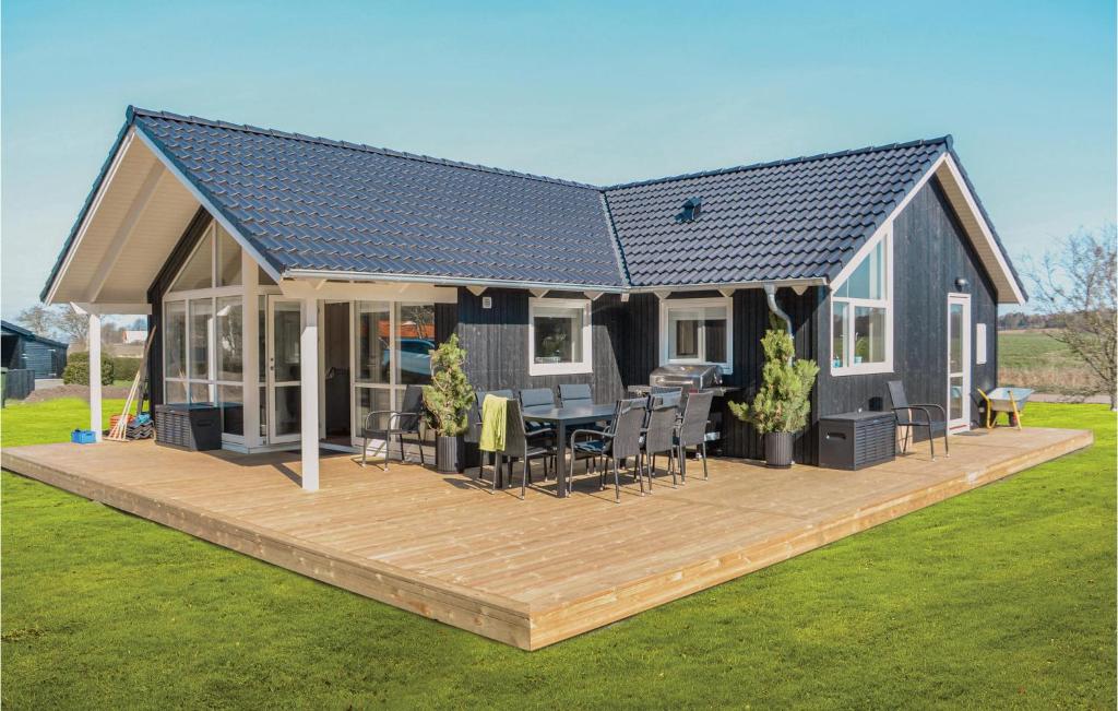 a house with a deck with a table and chairs at Three-Bedroom Holiday Home In Knebel in Knebel