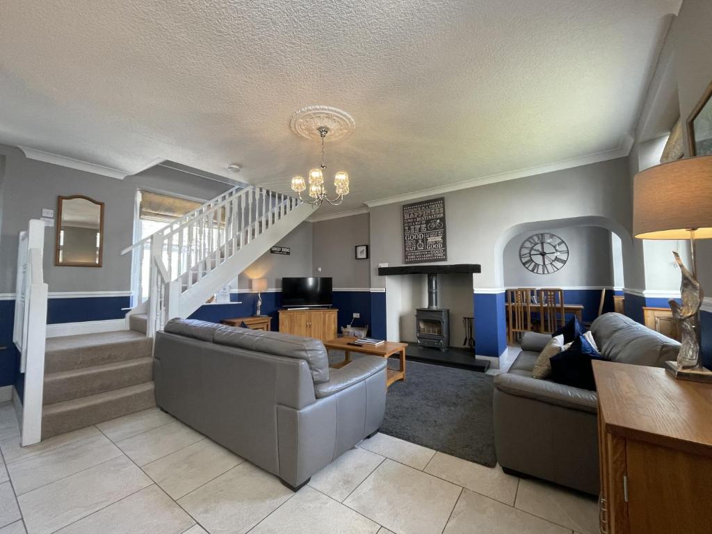 ein Wohnzimmer mit 2 Sofas und einer Treppe in der Unterkunft Bridge Cottage in Keswick