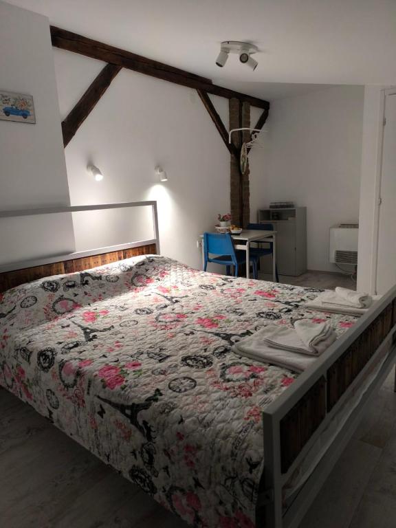 a bedroom with a bed with a floral bedspread at Apartment By the River in Niš