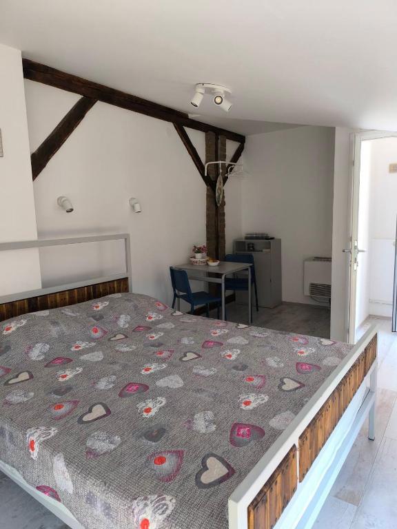 a bedroom with a bed in a room with a table at Apartment By the River in Niš