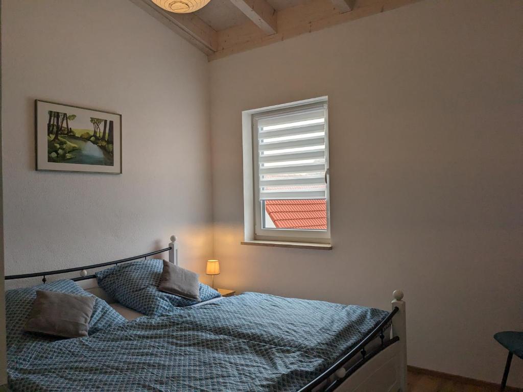 a bedroom with a bed and a window at Ferienwohnung Sonnenschein für bis 4 Personen in Bechhofen