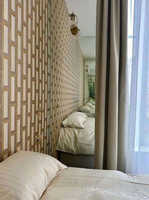 une chambre avec deux lits et une grande fenêtre dans l'établissement Otentik Art Déco, à Metz