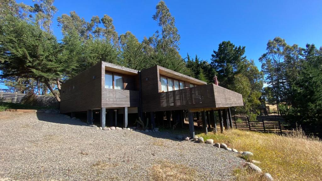 ein Holzhaus auf einem Hügel in der Unterkunft Casa Morro Punta de Lobos in Pichilemu