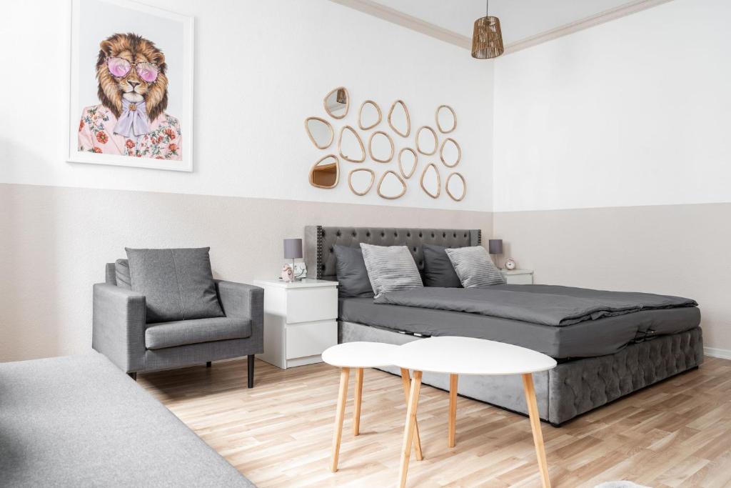 ein Wohnzimmer mit einem Bett und einem Stuhl in der Unterkunft SchaeBu! 12 Ferienwohnung im Herzen von Cottbus in Cottbus