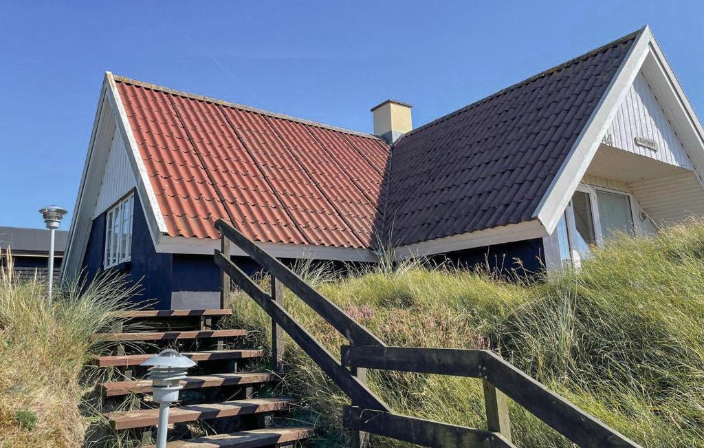 a house with a red roof and stairs in front at Holiday Home Fanø 24 in Fanø