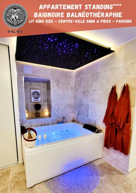 una vasca da bagno in un bagno con soffitto a stelle di - LA SUITE DELOS - JACUZZI 2 PLACES - CENTRE VILLE A PIED - LIT QUEEN SIZE - PARKING PRIVÉE - WIFI - City Center within walking distance - a Quimper