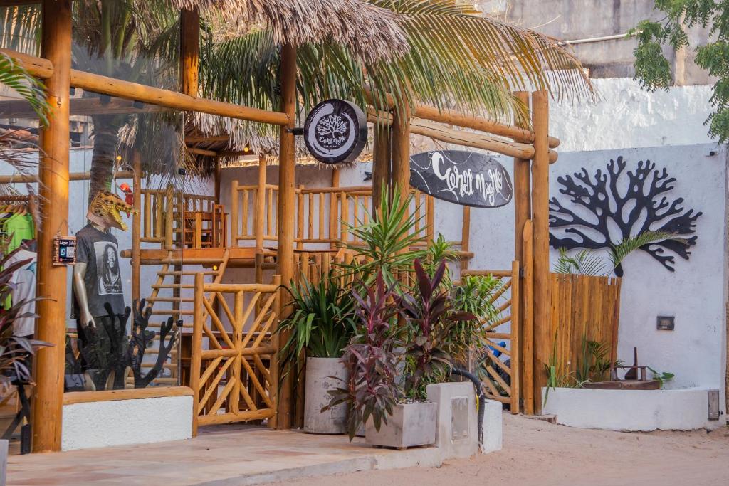 a restaurant with plants and a sign on a wall at Pousada Coral Negro in Jericoacoara