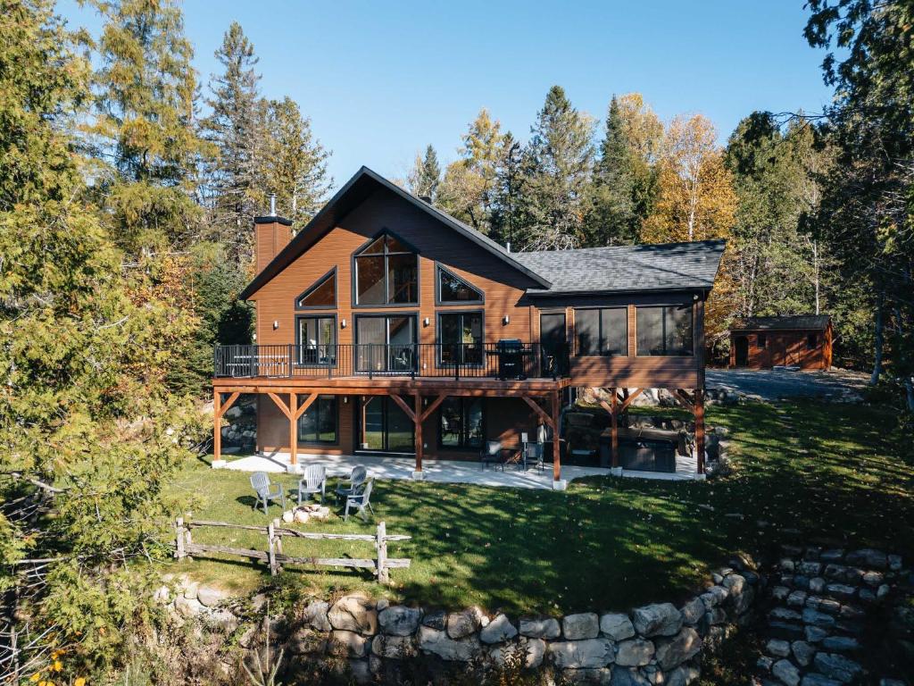 a large wooden house with a large deck at Le Plein Sud - Your ideal getaway by Lake Lise in Chertsey