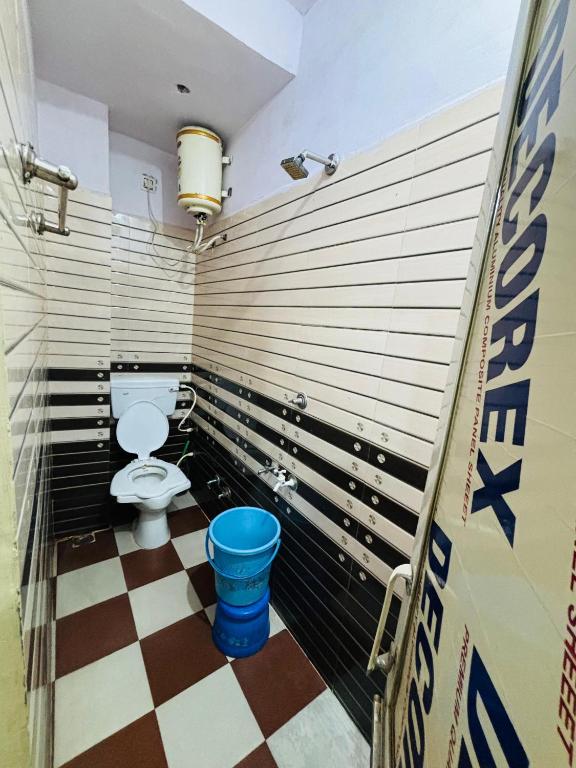 bagno con servizi igienici e pavimento a scacchi di Abhinandan Guest House Ujjain a Ujjain