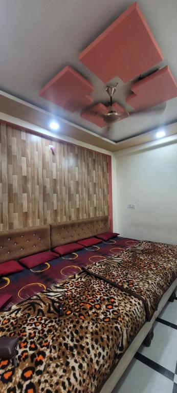una stanza con un letto con un tappeto ghepardo sul pavimento di Abhinandan Guest House Ujjain a Ujjain