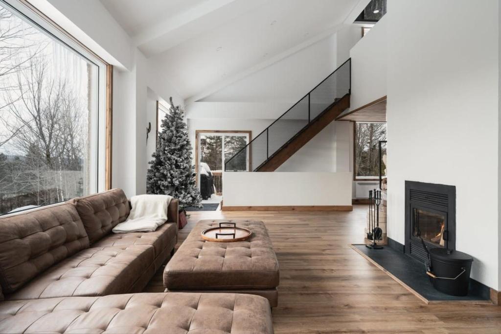 a living room with a couch and a fireplace at O Sommet -Game room-Spa-sauna-Lake Access in Chertsey