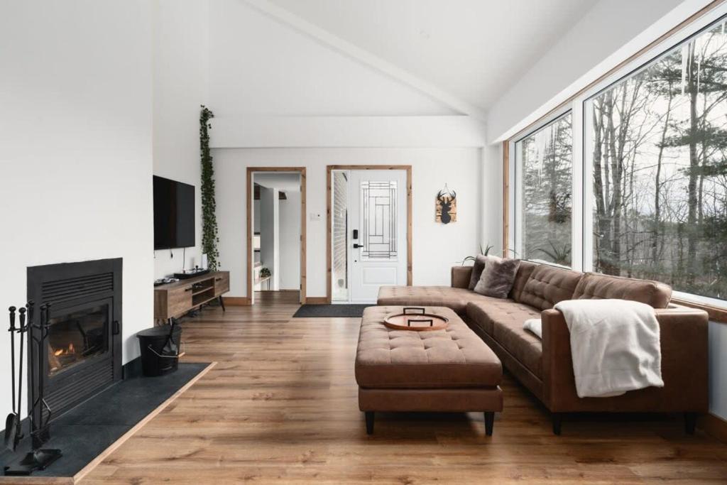 ein Wohnzimmer mit Couch und Kamin in der Unterkunft O Sommet -Game room-Spa-sauna-Lake Access in Chertsey