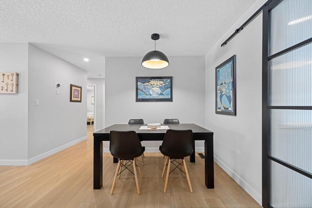 a dining room with a black table and chairs at Flora's House in Calgary