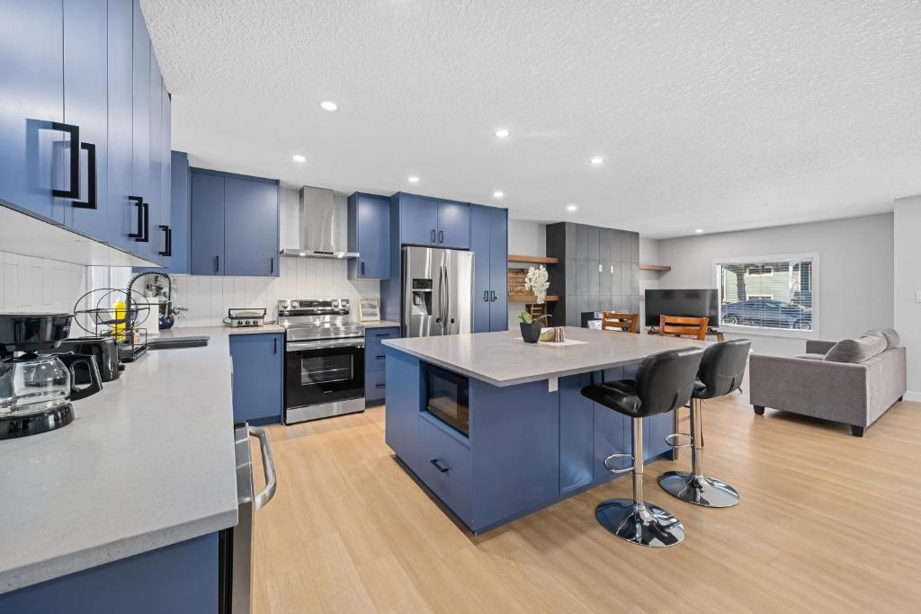 a large kitchen with blue cabinets and a kitchen island at Flora's House in Calgary
