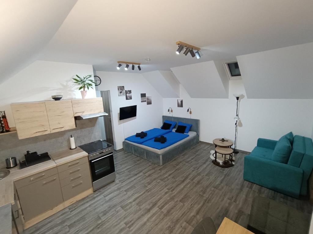 un soggiorno con divano blu e una cucina di Apartmán Pod Hrází Chráštany a Benešov
