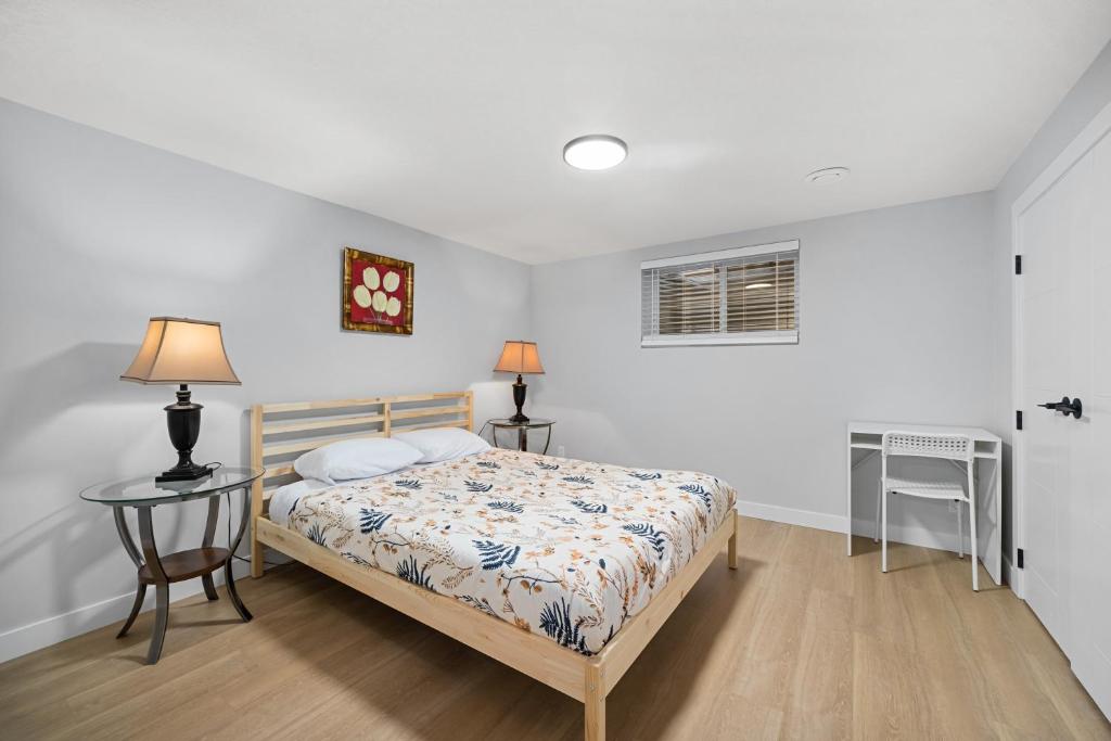 a bedroom with a bed and a table and a window at Flora's House in Calgary