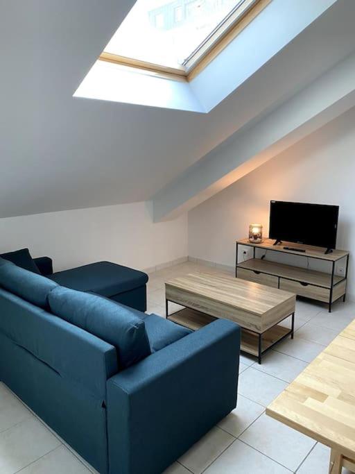 un salon avec un canapé bleu et une télévision dans l'établissement COSY 2 couchages - secteur SNCF - Parking, à Châlons-en-Champagne