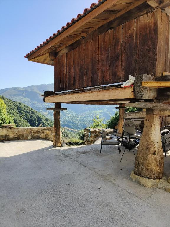 a wooden pavilion with chairs and a table with a view at Quirós Villa Tranquila de Salcedo 2 in La Villa