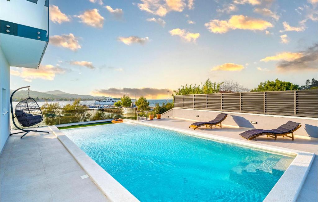 a swimming pool with two chairs on a house at Villa Tala in Mrljane