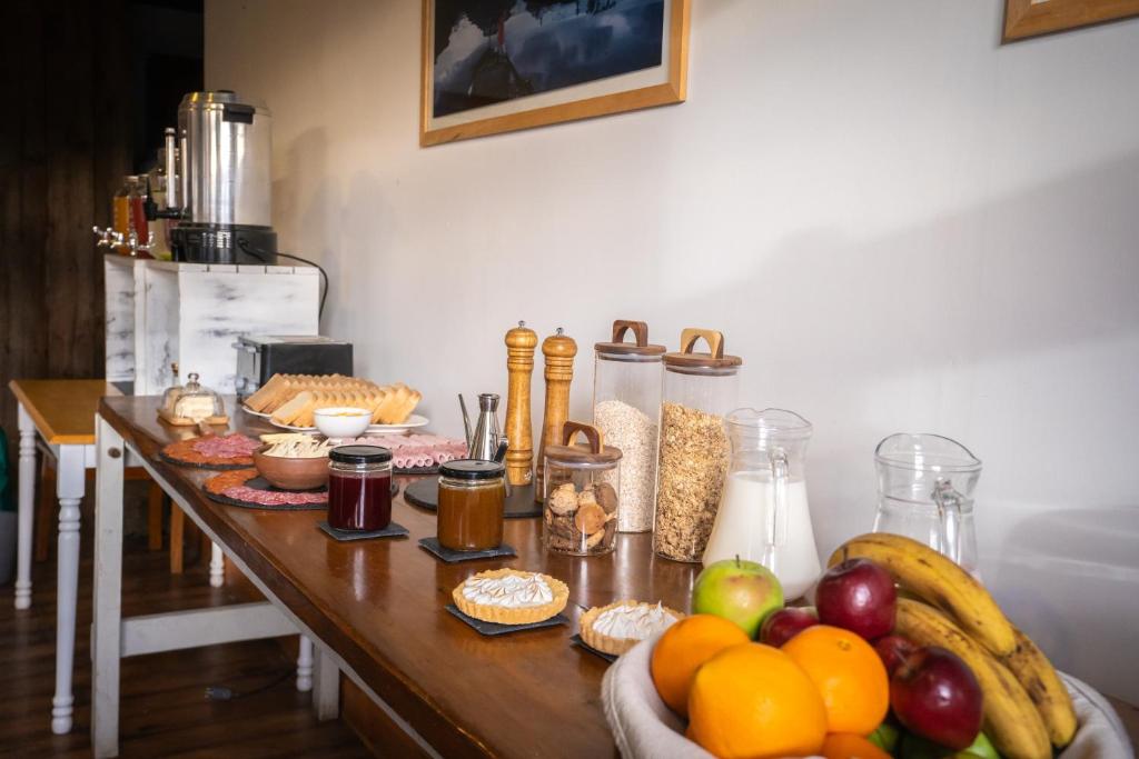 a table with a bunch of food and fruit on it at Pristine Patagonia Hotel in Puerto Natales