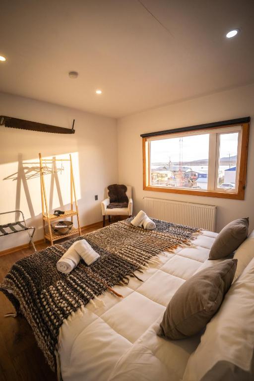 a large bed in a room with a large window at Pristine Patagonia Hotel in Puerto Natales
