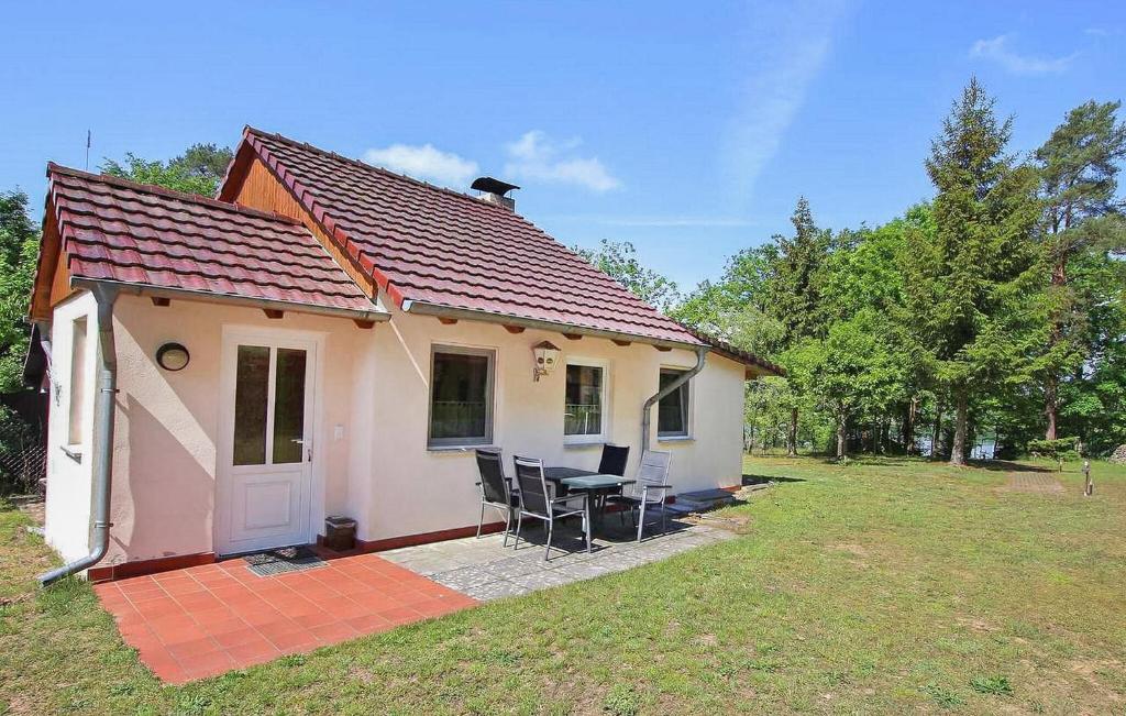 a small house with a table and chairs in a yard at Ferienhaus Rheinsberg in Scharfenberg