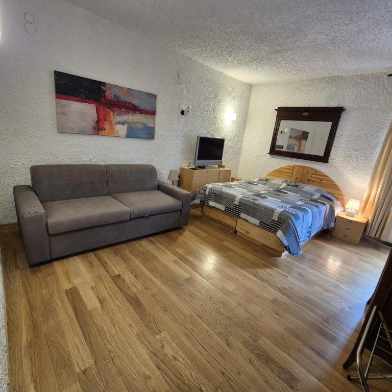 a living room with a couch and a bed at Come a casa in Rivisondoli