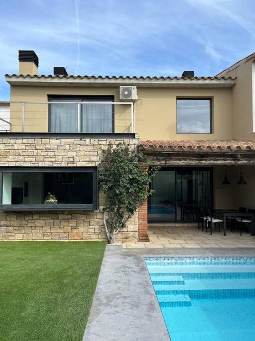 a house with a swimming pool in front of it at Casa Mont-mar in Montrás