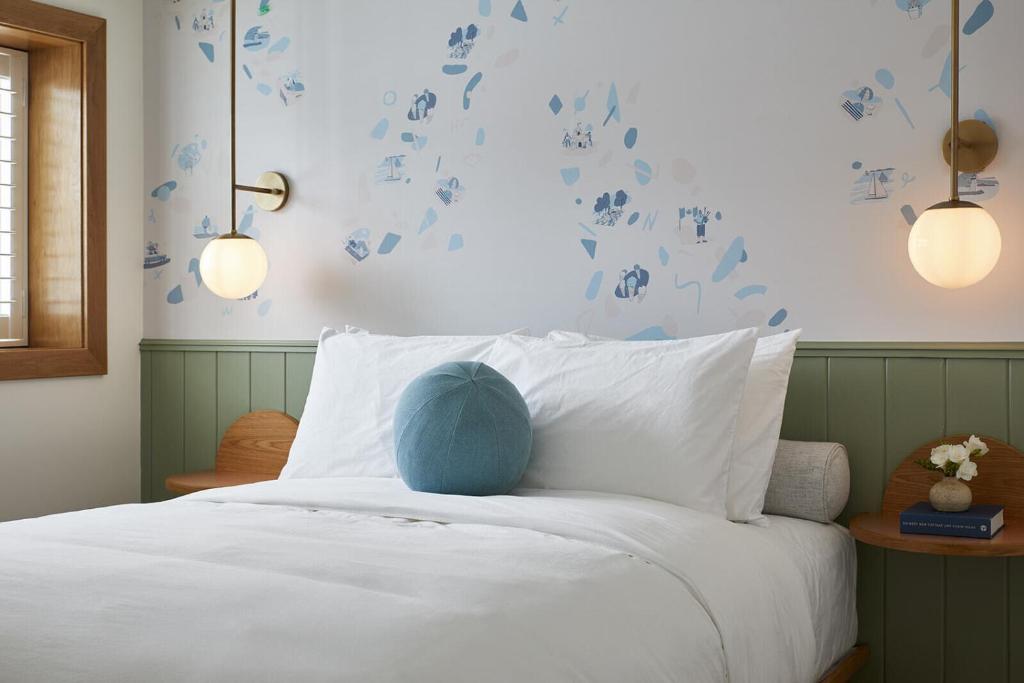 a bedroom with a bed with blue leaves on the wall at The Beach Motel in Southampton