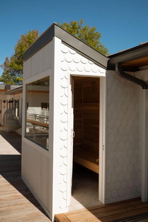 a white building with an open door on a deck at The Beach Motel in Southampton