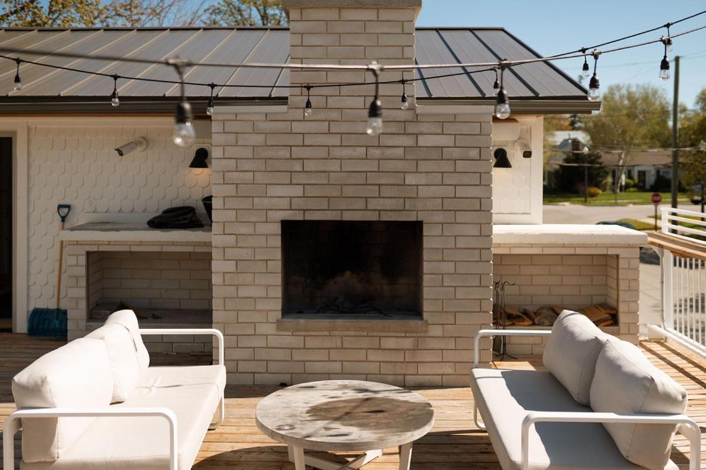 a patio with two white couches and a fireplace at The Beach Motel in Southampton